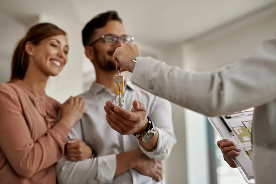 Couple receiving keys to their rented flat